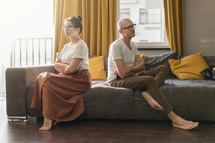 Eine Frau und ein Mann sitzen beleidigt auf einem Sofa